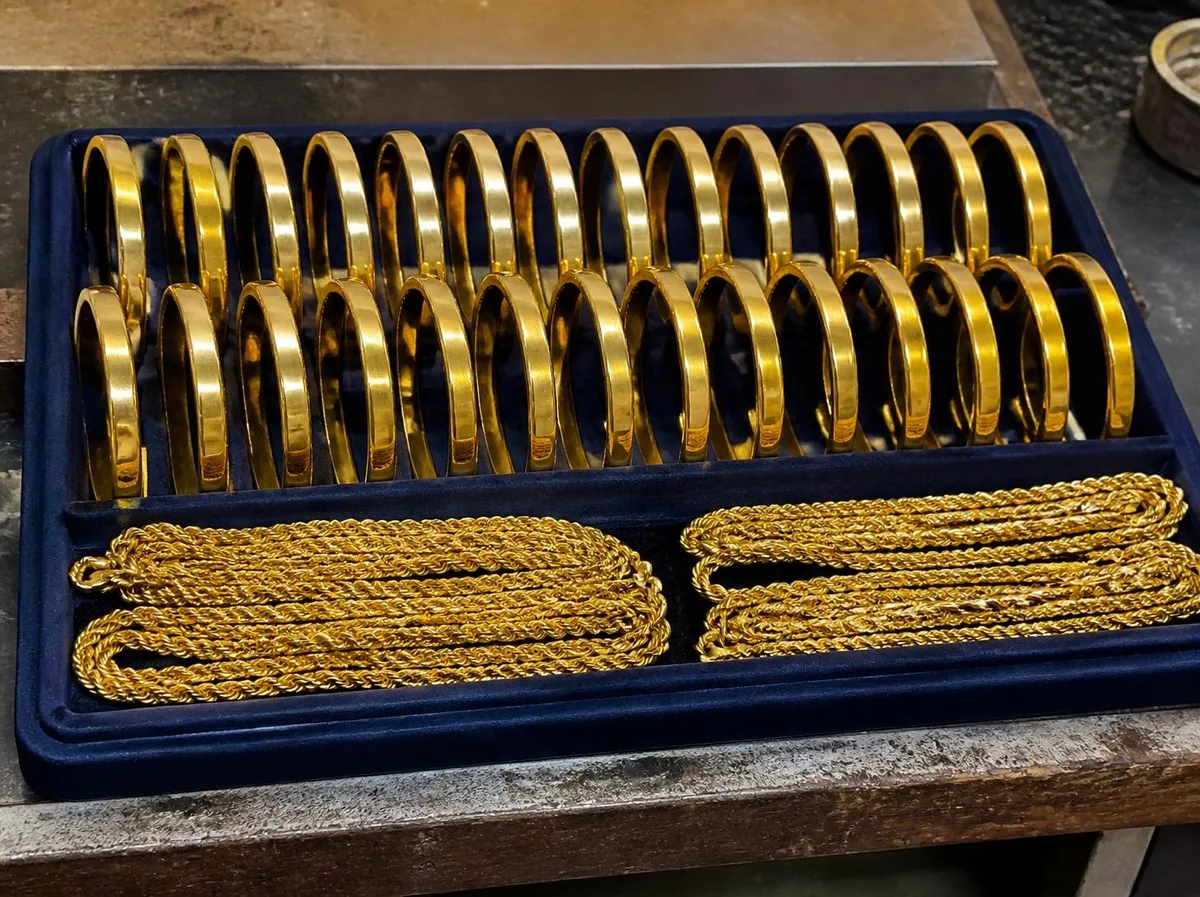 Illustration: a tray of plain gold kadas and coiled gold chains